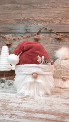 two santa hats sitting on top of a wooden table