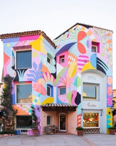 a multicolored building with an artistic mural on it's front and side