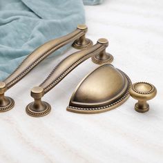 three brass knobs and handles on a bed