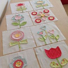 several pieces of paper with flowers on them sitting on top of a table next to each other