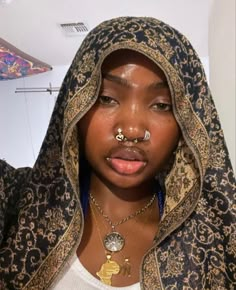 a woman with piercings on her nose wearing a hoodie