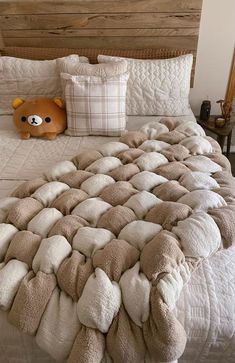 a teddy bear sitting on top of a bed in a room with wooden headboard