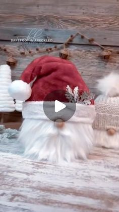 two santa claus hats sitting on top of a wooden table next to snowflakes