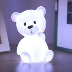 a white teddy bear sitting on top of a wooden table