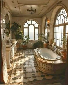 a large bathroom with an arched window and checkered tile flooring, along with a jacuzzi tub surrounded by potted plants