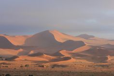 sand dunes in the desert under a cloudy sky