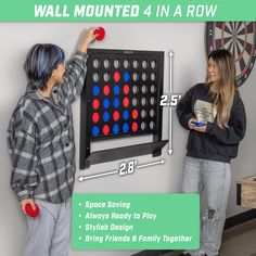 two children playing with the giant connect 4 in a row board game on a wall