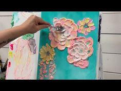 someone is painting flowers on a canvas with acrylic paint and watercolors