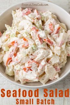 a white bowl filled with seafood salad on top of a table