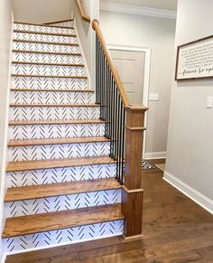 the stairs are painted with white and black herringbones on them, along with wood handrails