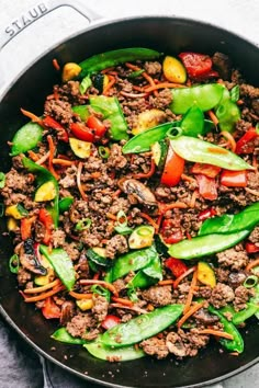 a skillet filled with ground beef, peppers, and other vegtables