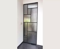 an open door with glass panels on the side and black flooring in front of it