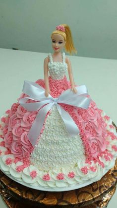 a barbie doll cake with pink and white frosting