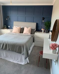 a bed sitting in a bedroom next to a white dresser and window with blue paneling