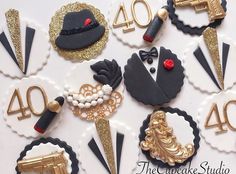 the cake is decorated with black and gold decorations, including an assortment of top hats