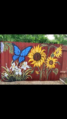 a painted fence with sunflowers and butterflies on it