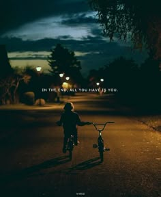 a person riding a bike at night with the words in the end all you have is you