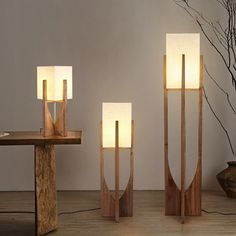 three wooden lamps sitting next to each other on a table