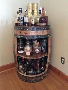 a wooden barrel filled with liquor bottles on top of a hard wood floor