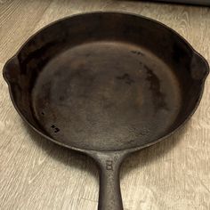 an old cast iron skillet sitting on top of a wooden table