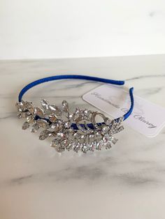 A Bespoke bridal headband with vintage Brooch detail. Hand-crafted with Silver plated wire and premium rhinestone crystals. This hairband is also wrapped with Royal Blue ribbon. This gorgeous piece sits comfortably in most hairstyles and sparkles in both natural sunlight and artificial light. Made with love by myself. If you have any questions, please let me know! Clairey x Bridal Hairband, Artificial Light, Blue Bridal, Rhinestone Bridal, Natural Sunlight, Bridal Headband, Vintage Brooch, Blue Ribbon, Wedding Hair Accessories