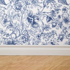 a blue and white flowered wallpaper in an empty room with wood flooring