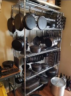 a rack filled with pots and pans on top of a wooden floor