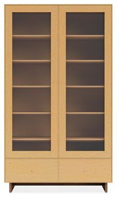 a wooden bookcase with glass doors on the front and bottom shelves in light wood