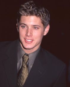 a young man wearing a suit and tie