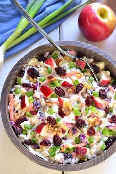 a bowl filled with fruit and nuts on top of a table next to an apple