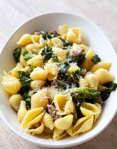 a white bowl filled with pasta and broccoli