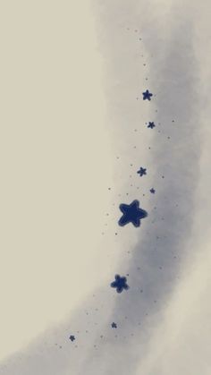 several blue stars are flying in the sky above some clouds and one is upside down