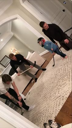 three people standing in a living room holding ski poles