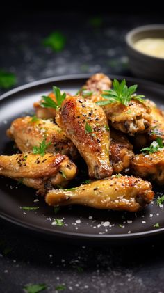 chicken wings with parsley on a black plate