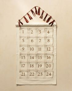 a calendar hanging on the wall with some clothes pins attached to it's side