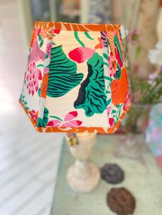 a lamp that is sitting on a table next to some cookies and flowers in vases