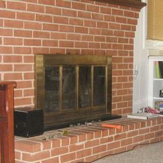 a living room with a brick fireplace and bookshelf