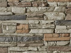 a stone wall that is made out of several different types of stones and has various colors