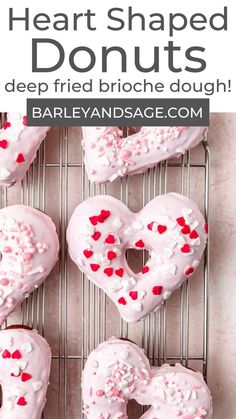 heart shaped doughnuts on a cooling rack with sprinkles and hearts