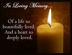 a lit candle with the words in loving memory