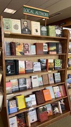 a book shelf filled with lots of books on top of wooden shelves in a library