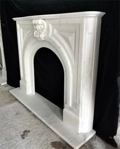 a white marble fireplace surround on display