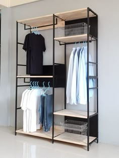 an open closet with clothes hanging on racks