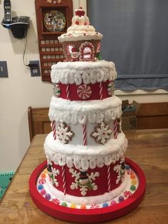 a large red and white cake on top of a wooden table with candy canes