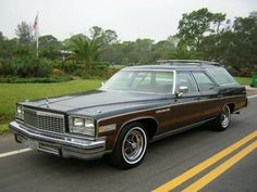 an old station wagon is parked on the side of the road