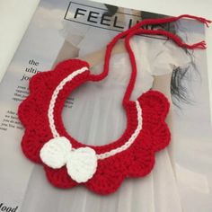 a crocheted red and white necklace with a bow