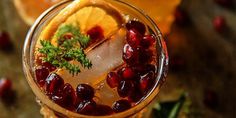 an orange and cranberry punch in a glass with garnish on the rim