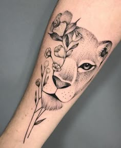 a black and white photo of a lion's face with flowers on its head