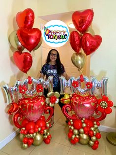 a woman standing in front of balloons and decorations for a happy birthday party with her name written on them