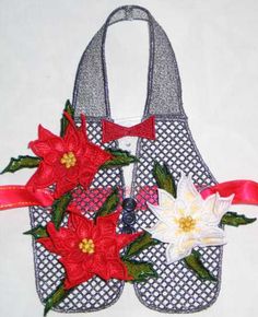 a purse with flowers on it sitting on a white tableclothed surface and red ribbon around the handles